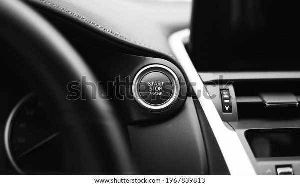 Car engine start button black and white\
close-up with blurred\
background