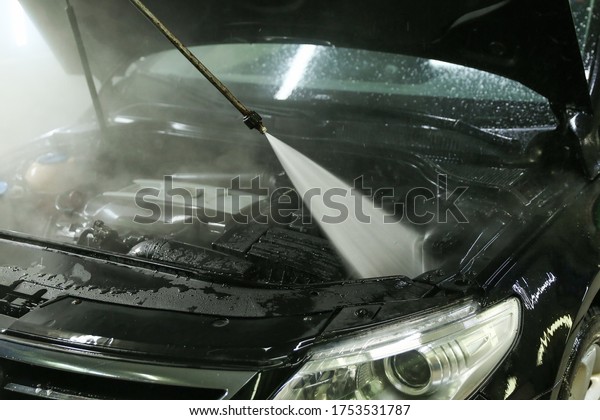 car\
engine washing with pressure jet of water close-up.\

