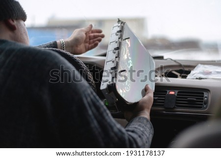 Car engineer is disassembling a car dashboard close up.