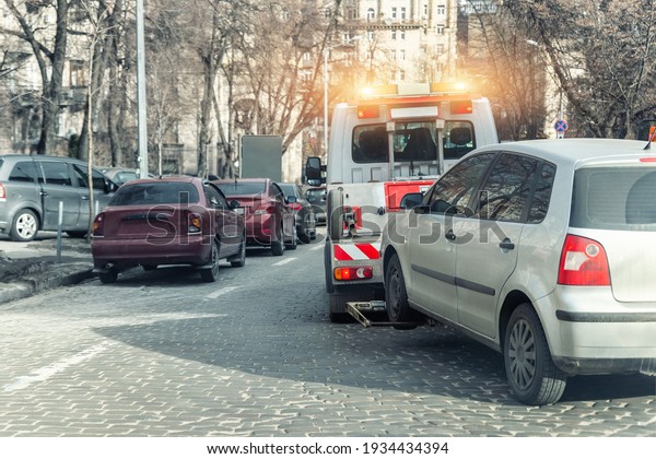 Car evacuation police service by tow truck
machine on city downtown street center due parking traffic rules
violation. Emergency road assistance service motorway. Automotive
trailer carrier transport.