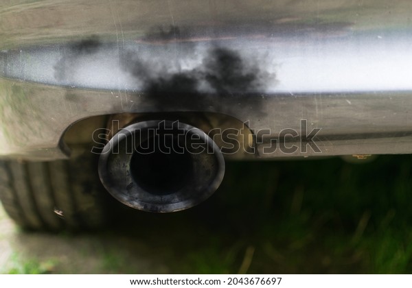 Car exhaust pipe and black smoke. Pollution caused\
by diesel-concept cars.