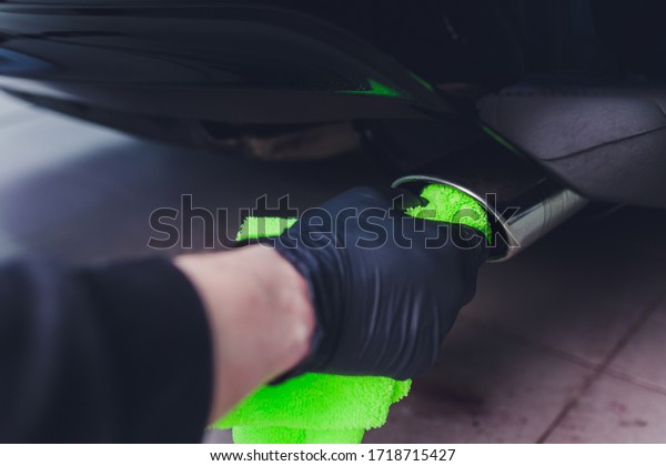 Car exhaust pipe with soap. Car wash background.\
close-up of a green rag