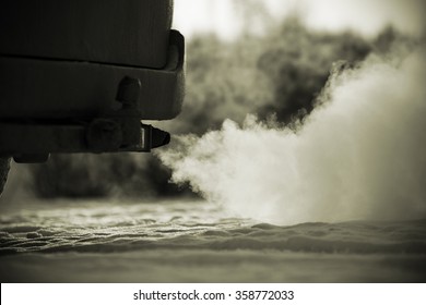 Car exhaust pipe, which comes out strongly of smoke in Finland. Focal point is the center of the photo. Background out of focus. Image includes a effect.
