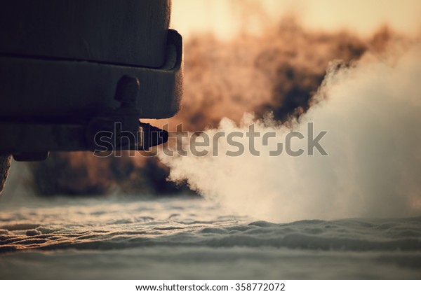 Car exhaust pipe, which comes out\
strongly of smoke in Finland. Focal point is the exhaust pipe.\
Background out of focus. Image includes a vintage\
effect.