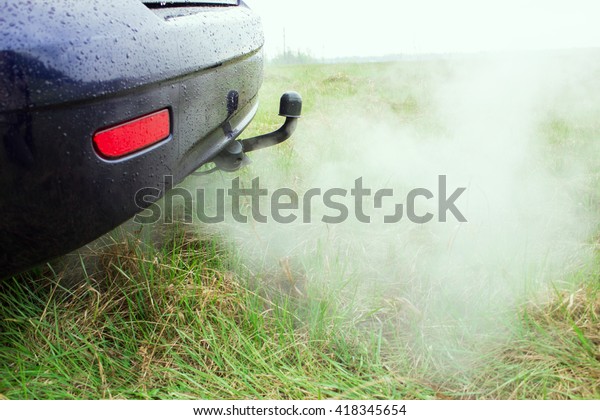 Car exhaust pipe, which comes out strongly of\
smoke.  a car\'s fumes emissions\
