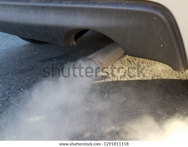 car exhaust or smoke\
and black asphalt