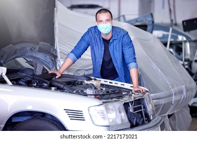 Car, Face Mask And A Mechanic In Workshop During Covid, Safety, And Insurance At Work. Working, Maintenance And Quality Assurance, Man In A Garage With Vehicle And Small Business Car Mechanic Startup