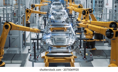 Car Factory 3D Concept: Automated Robot Arm Assembly Line Manufacturing High-Tech Green Energy Electric Vehicles. Automatic Construction, Building, Welding Industrial Production Conveyor. Front View - Shutterstock ID 2075069920