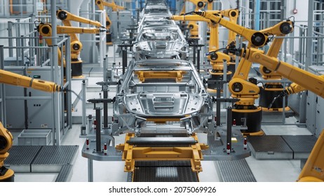Car Factory 3D Concept: Automated Robot Arm Assembly Line Manufacturing High-Tech Green Energy Electric Vehicles. Automatic Construction, Building, Welding Industrial Production Conveyor. Front View - Shutterstock ID 2075069926