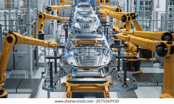 Car Factory 3D Concept: Automated Robot Arm Assembly\
Line Manufacturing High-Tech Green Energy Electric Vehicles.\
Automatic Construction, Building, Welding Industrial Production\
Conveyor. Front View