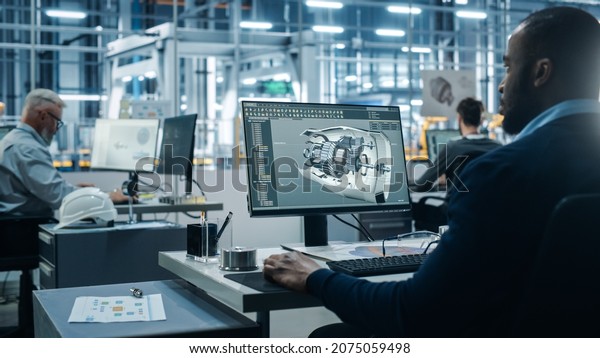 Car Factory Office: Engineer Working on Turbine\
Prototype on Computer, Design Advanced 3D Model for High-Tech Green\
Energy Electric Engine. Diverse Team Work in Automated\
Manufacturing Facility