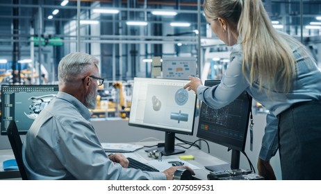 Car Factory Office: Female Project Manager Talks To Male Chief Automotive Engineer Working On Computer. Monitoring, Control, Equipment Design. Automated Robot Arm Assembly Line Manufacturing Vehicles