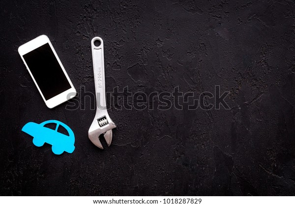 Car failures. Car service\
concept. Car silhouette, wrench on black backgound top view copy\
space