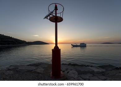 Car Ferry In The Background Of Solar Powered Beacon Near The Port Of Muna On The Island Zirje In Croatia