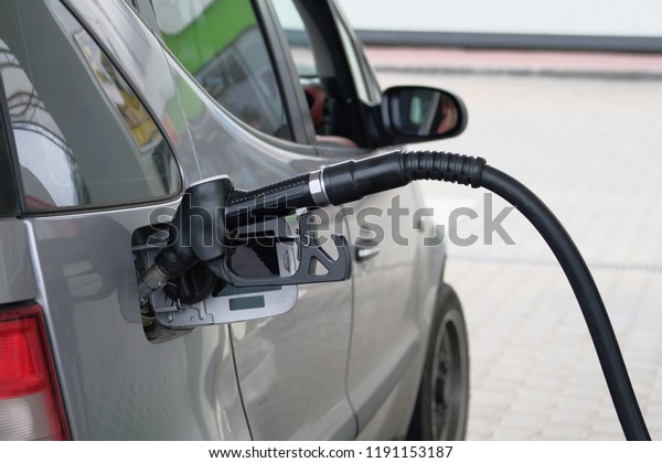 Car fill with gasoline\
at gas station. Close up of pumping gasoline fuel in gray car at\
gas station.