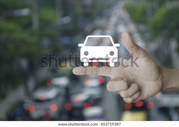 Car flat icon on finger over\
blur of rush hour with cars and road, Business service car\
concept