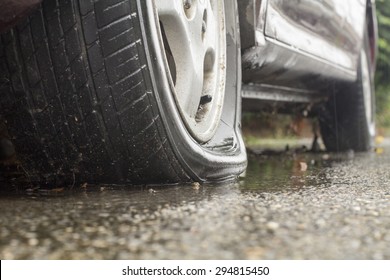 Car flat tire in rainy day - Shutterstock ID 294815450