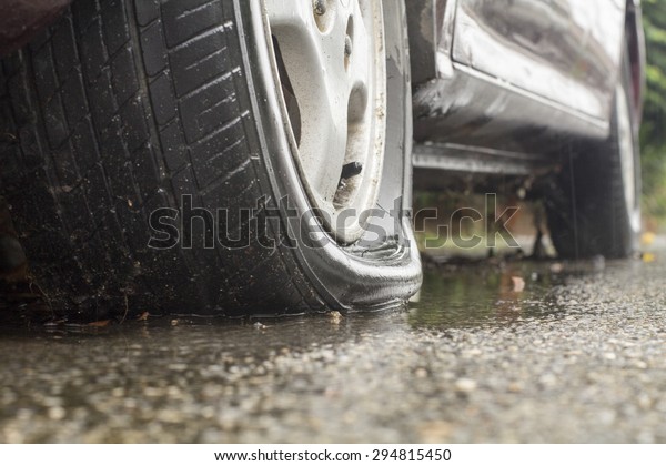 Car flat tire in rainy\
day