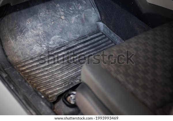 Car floor mats that are dirty with dust, dirt,\
sand and small rocks. which urgently needs to be cleaned to make\
the car look better.