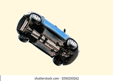 A Car Flying Through The Air (in The Pale Blue Sky) With The Underside Including, Wheels, Engine And Exhaust Pipe Visible