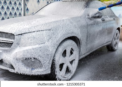 Car in foam. Car getting a wash with soap, car washing.