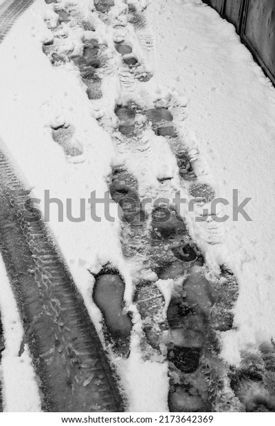 Car and foot\
tracks in the snow, snowy\
road.