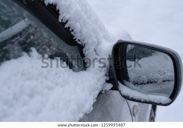 car fragment with\
side mirror in the snow