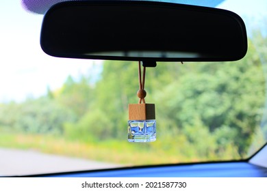 Car Fragrance In The Form Of A Glass Bottle Hangs On The Rearview Mirror