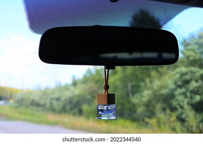 Car Fragrance In The Form Of A Glass Bottle Hangs On The Rearview Mirror