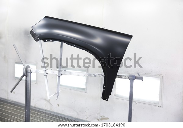 car\
front fender in spray booth  prepared for\
painting