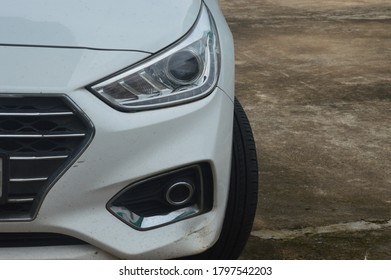 A Car Front Half View Parked With Headlight And Tyre Small Dent