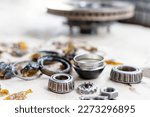 Car front wheel bearings, dust seals, brake discs, old grease and various parts of the car front wheel on floor, Auto part remove and car maintenance concept 
