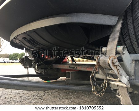 Car front wheels loaded onto towing dolly transport