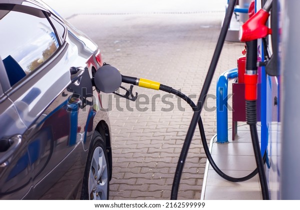 Car fueling at gas station. Petrol pump filling\
fuel nozzle in fuel tank of car at gas station. Petrol industry and\
service.