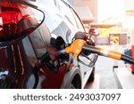 Car fueling at gas station. Refuel fill up with petrol gasoline. Petrol pump filling fuel nozzle in fuel tank of car at gas station. Petrol industry and service. Petrol price and oil crisis concept.