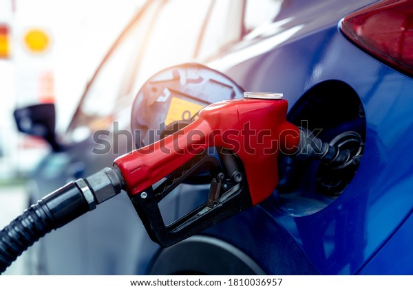 Car fueling at gas station. Refuel fill up with
petrol gasoline. Petrol pump filling fuel nozzle in fuel tank of
car at gas station. Petrol industry and service. Petrol price and
oil crisis concept.