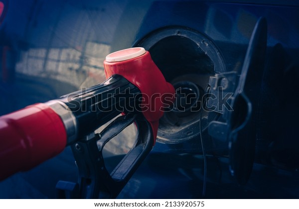 Car fueling at gas station. Refuel fill up with\
petrol gasoline. Petrol pump filling fuel nozzle in fuel tank of\
car at gas station. Petrol industry and service. Petrol price and\
oil crisis concept.