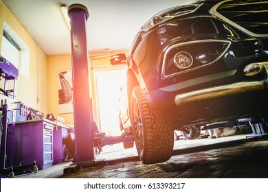 Car In Garage Of Auto Repair Service Shop With Special Repairing Equipment