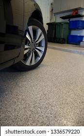 Car in garage with epoxy floor coating over concrete.