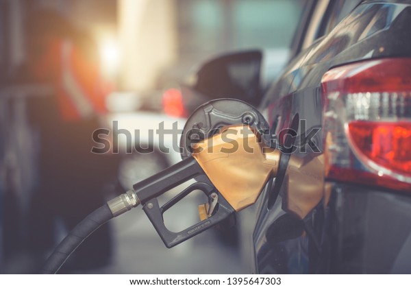Car gas\
nozzle auto filling refuel fill up with premium petrol gasoline at\
gas station, Close up. \
Gas pump nozzle in fuel tank of bronze\
car, refuel petroleum to vehicle at gas\
station.