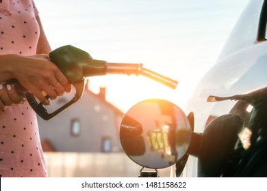 Car gas nozzle refuel fill up with petrol gasoline at a gas station.  Pretty young woman refuel the car. Transportation and ownership concept. - Powered by Shutterstock