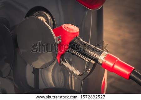 Car gas nozzle refuel with gasoline at a gas station. Filling a vehicle?s petrol tank with high-octane petroleum. The concept of fuel costs and rising or falling oil prices. Diesel fuel. Eco problem