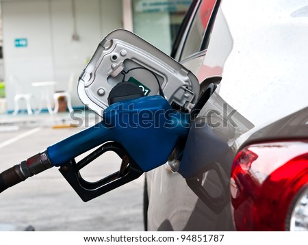 A car at gas station being filled with fuel