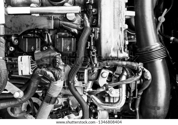 Car gasoline engine. Car engine part. Close-up\
image of an internal combustion engine. Engine detailing in a new\
car. Black and white. Top\
view