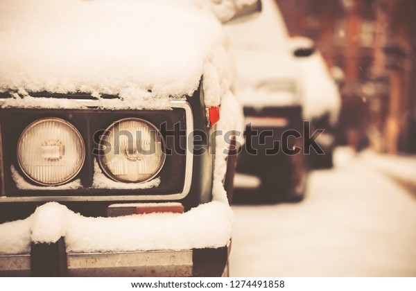 Car\
getting covered with snow during snow storm. Parked car covered\
with snow - snow storm, car after a heavy\
snowfall.