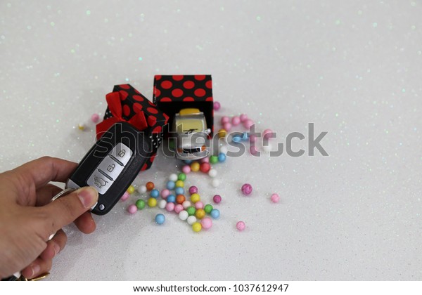 Car with gift package and colorful bubbles on the white\
background  