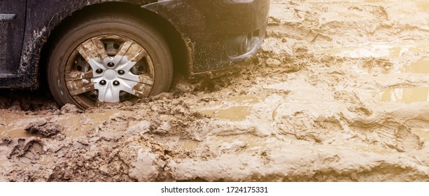 The Car Got Stuck On A Dirt Road In The Mud. Wheel Of A Car Stuck In The Mud On The Road. Car On A Dirt Road.