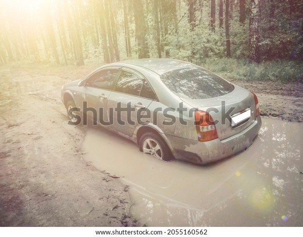 The car got stuck in a puddle on a dirt
road. A trip in the forest by car. Solar illumination of the frame.
Selective focus, blur, grain, noise,
defocused