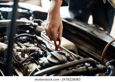 Car, hand and mechanic with person in workshop for maintenance, repair or service of engine. Auto, expert and inspection with vehicle engineer or technician checking dipstick for oil level in garage