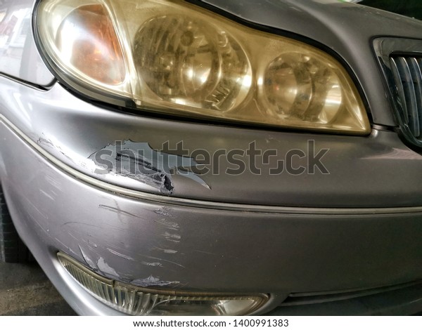 Car has a dented rear bumper after\
an accidentally and​ Yellow stains on the car\
headlights
